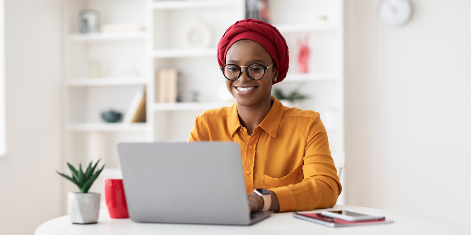 Woman with head scarf sitting in front of laptop